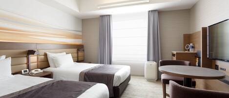 A hotel room with two beds, a desk, a chair, a television, and a large window with curtains.