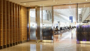 Una terminal aeroportuaria espaciosa con un diseño moderno, que cuenta con un techo alto, paredes de vidrio y un suelo pulido.