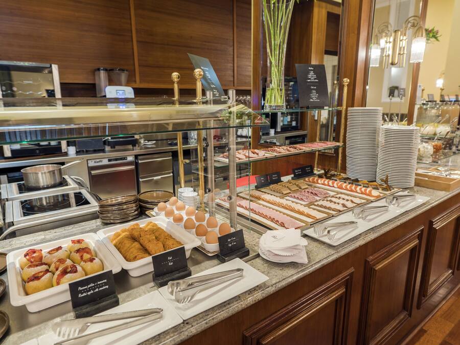 A buffet with various food items, including pastries, eggs, and meats.