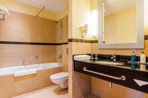 A bathroom with a bathtub, toilet, and sink.