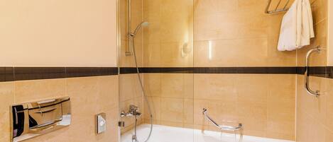 A modern bathroom with a glass-enclosed shower, a standalone bathtub, and a towel rack.