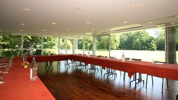 A conference room with a long table, chairs, and a red carpet.