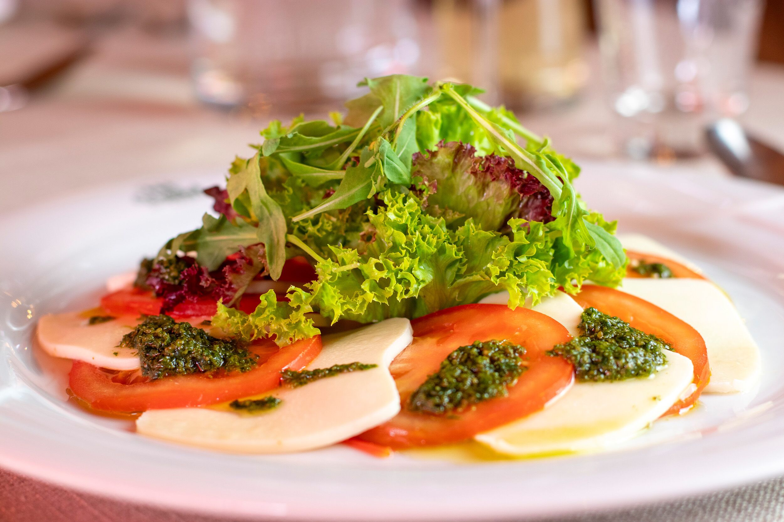 A plate of Caprese salad with tomatoes, mozzarella, and basil.