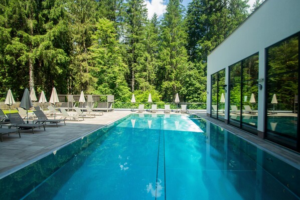 Piscine couverte, piscine extérieure, parasols de plage, chaises longues