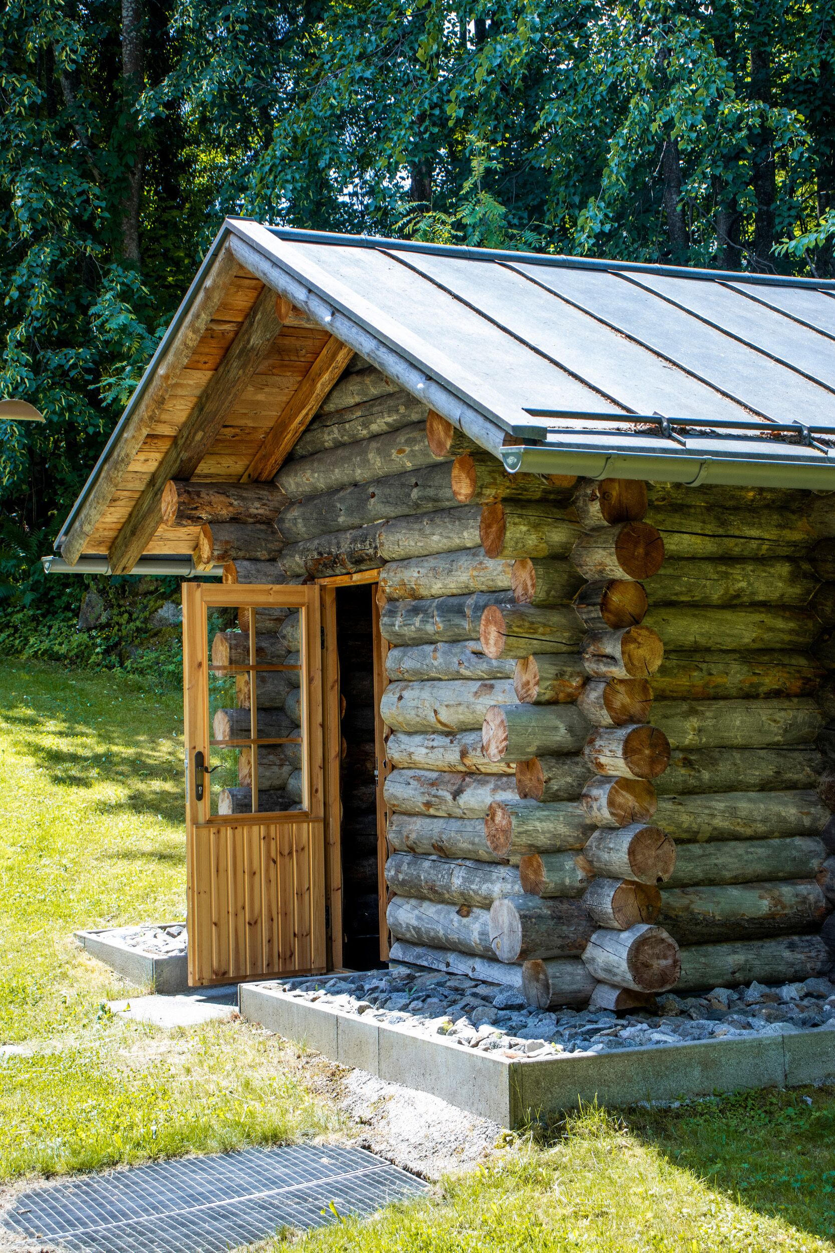 Une cabane en rondins avec une porte en bois et un petit porche.