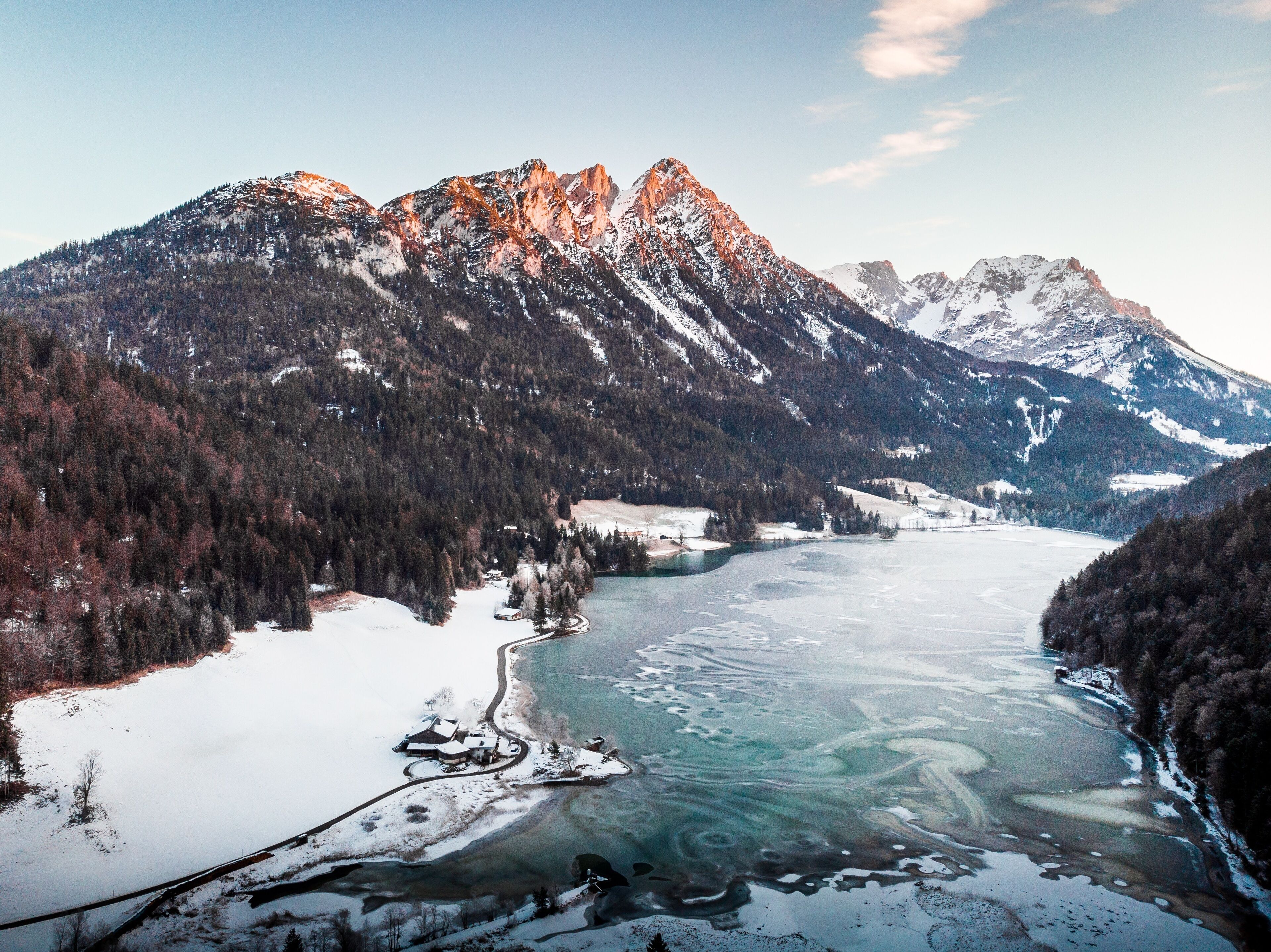 A mountainous landscape with a frozen lake and snow-covered peaks.