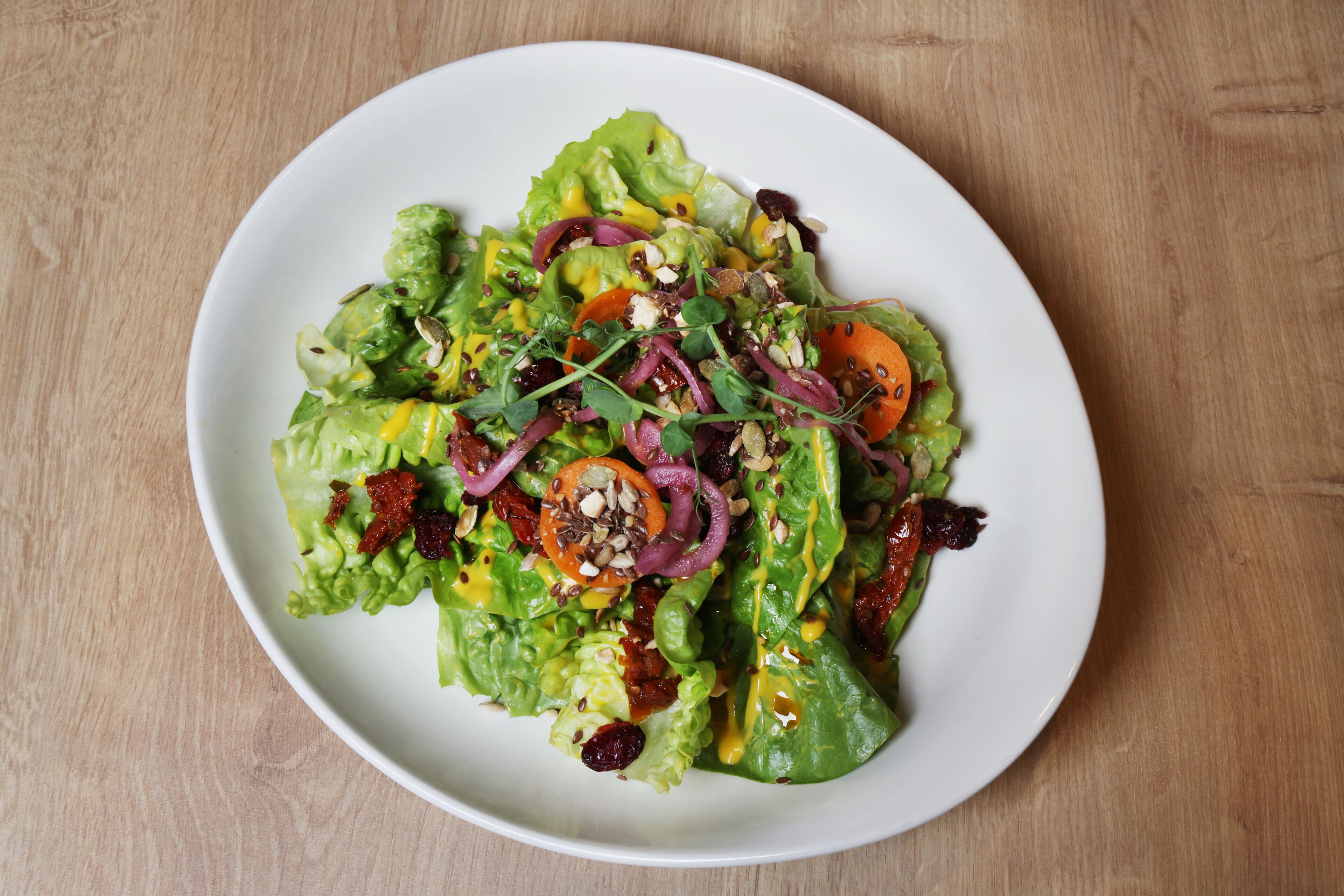 A plate of mixed greens salad with various toppings.