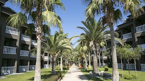 A pathway lined with palm trees and a building with balconies. - Sailor's Beach Club - All Inclusive (Kemer)