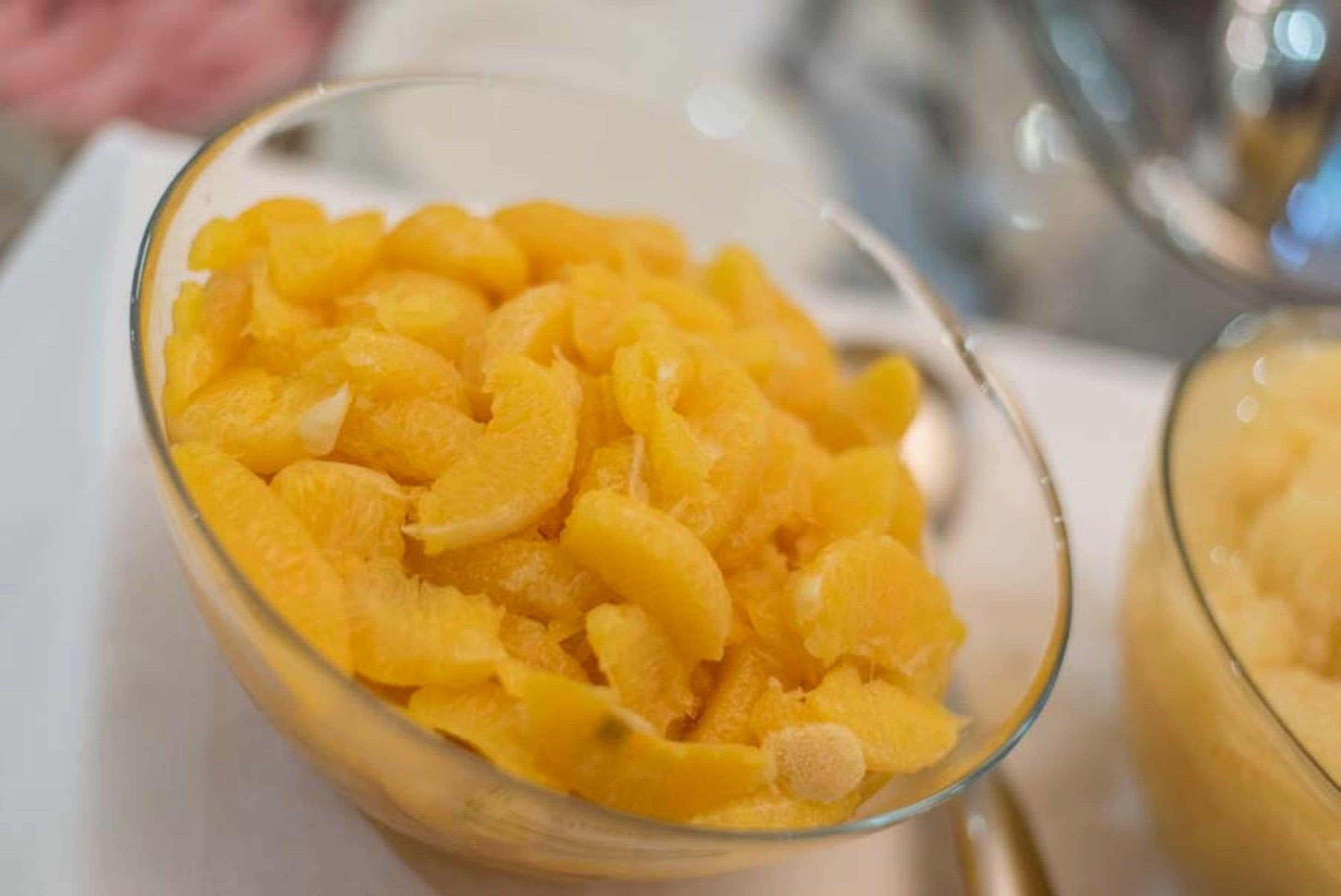 A clear glass bowl filled with orange fruit pieces.