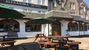 L’hôtel Alexandra dispose d’un espace extérieur aménagé avec des tables de pique-nique et des parasols.