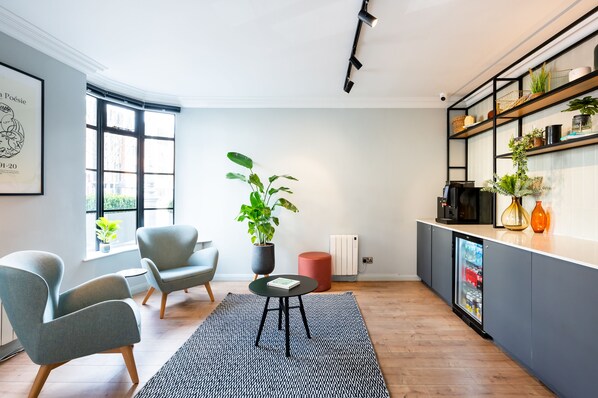 A modern living room with a sofa, armchairs, a coffee table, and a potted plant. - Staycity Aparthotels, Dublin, Christchurch (Dublin)