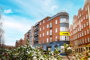 A multi-story building with a StayCity sign, a Synnott & Synnott law firm, and a blue awning. - Staycity Aparthotels, Dublin, Christchurch (Dublin)