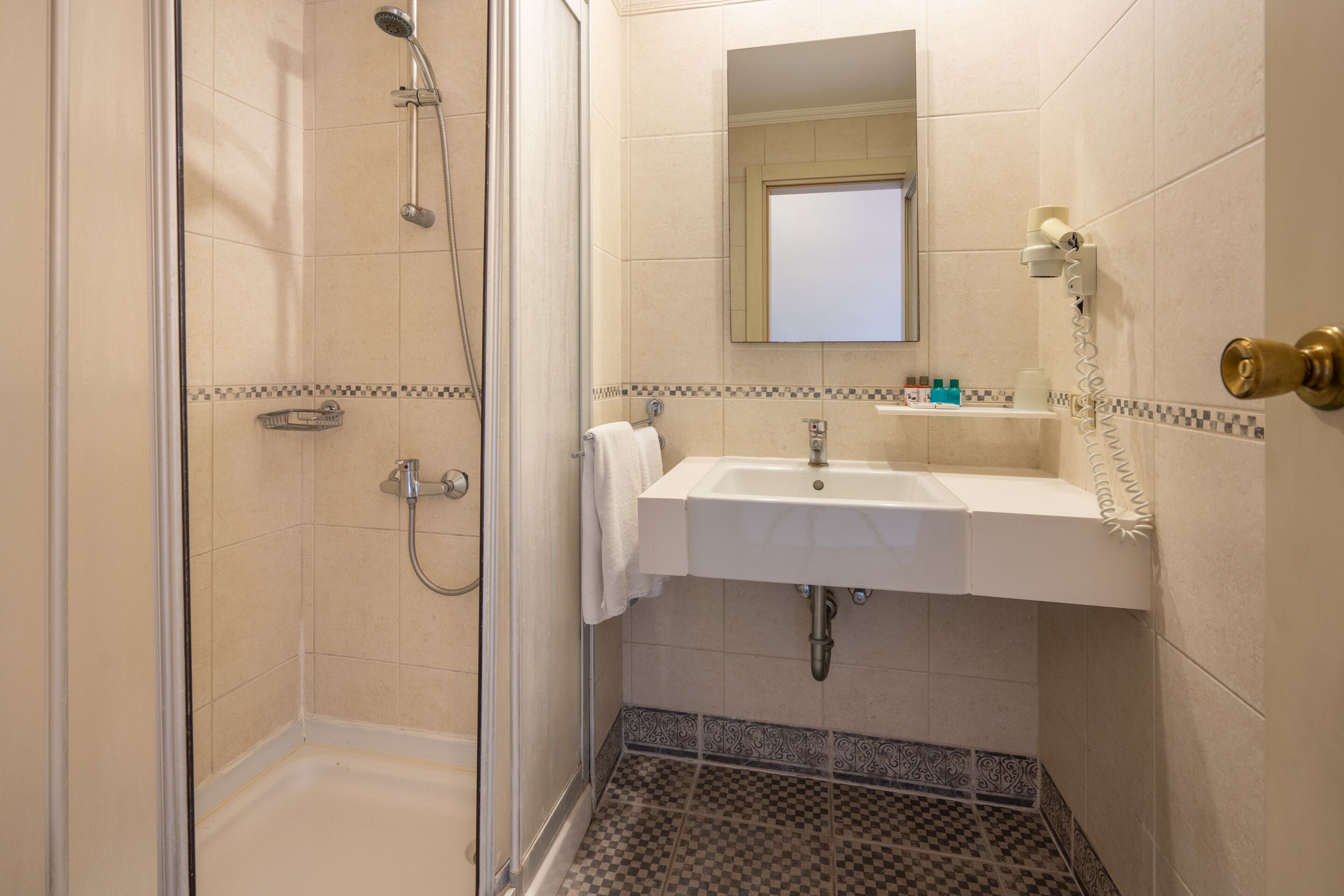 Ein Badezimmer mit Dusche, Waschbecken und Spiegel.
