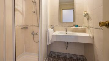 Ein Badezimmer mit Dusche, Waschbecken und Spiegel.