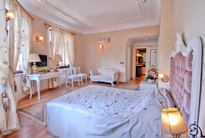 Un dormitorio con una cama grande, un escritorio, una silla y un televisor.