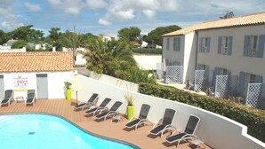 A swimming pool with sun loungers and a sign indicating a regulated pool. - Appart'hôtel Perle de Ré (La Couarde-sur-Mer)