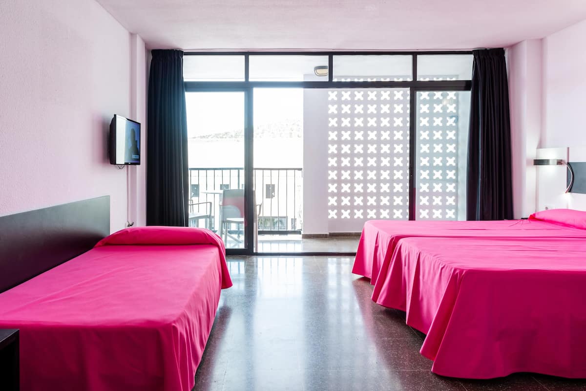 A hotel room with two beds, a TV, and a large window with a view.