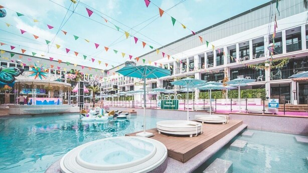 Une piscine intérieure dotée de jacuzzis, de parasols et d’une décoration sur le thème des tropiques.