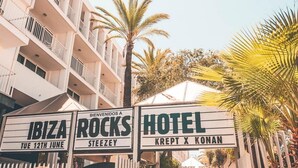 Un hôtel appelé « Hotel Krept X Konan », doté de balcons et bordé de palmiers.