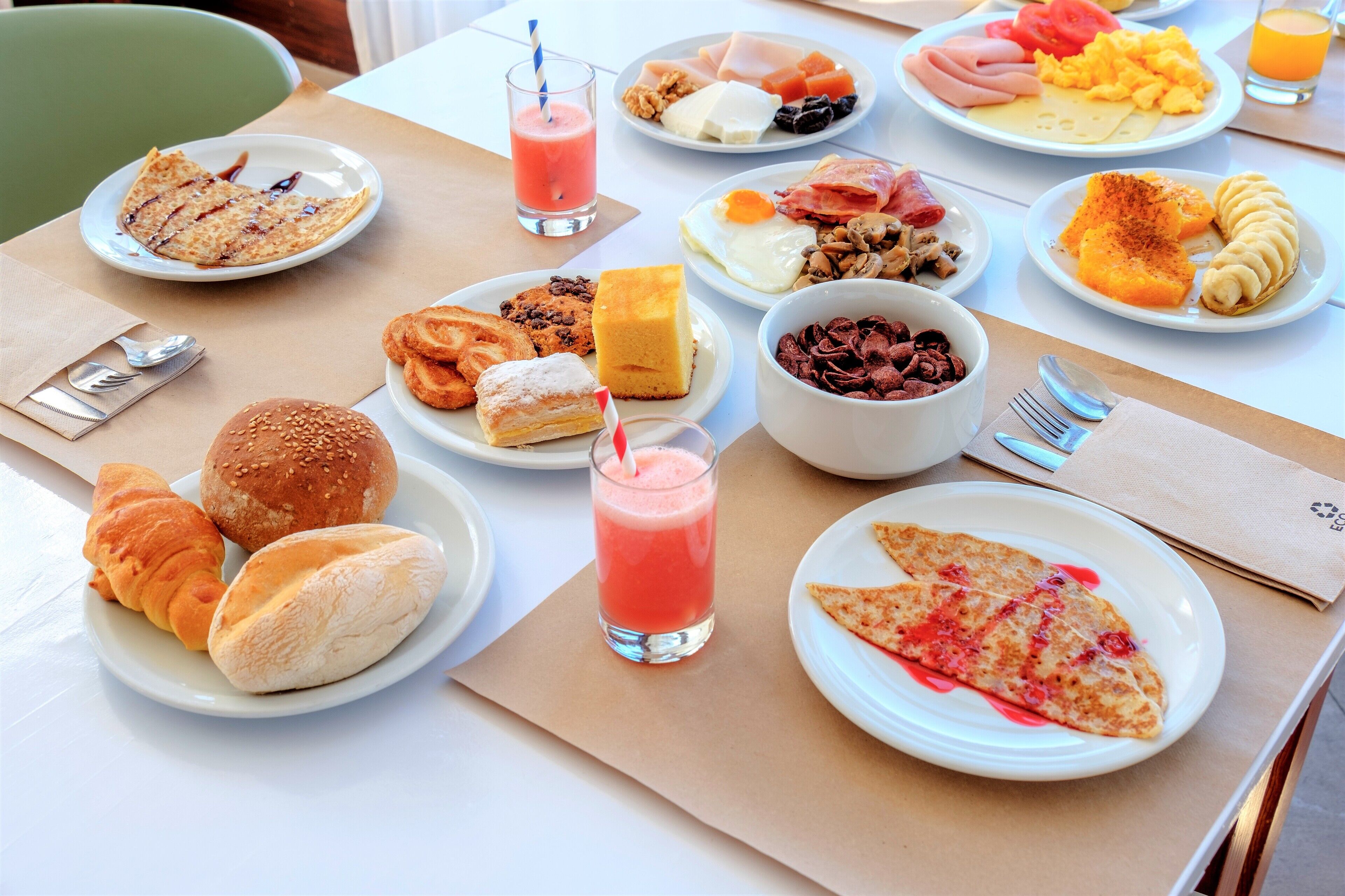 Un buffet della colazione con diversi piatti e bevande.
