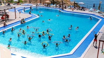 Relax by the pool surrounded by lounge chairs and umbrellas.