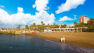 Una playa cerca, sillas reclinables de playa, sombrillas
