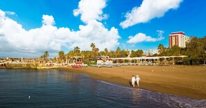 Nära stranden, solstolar, parasoller och strandhanddukar