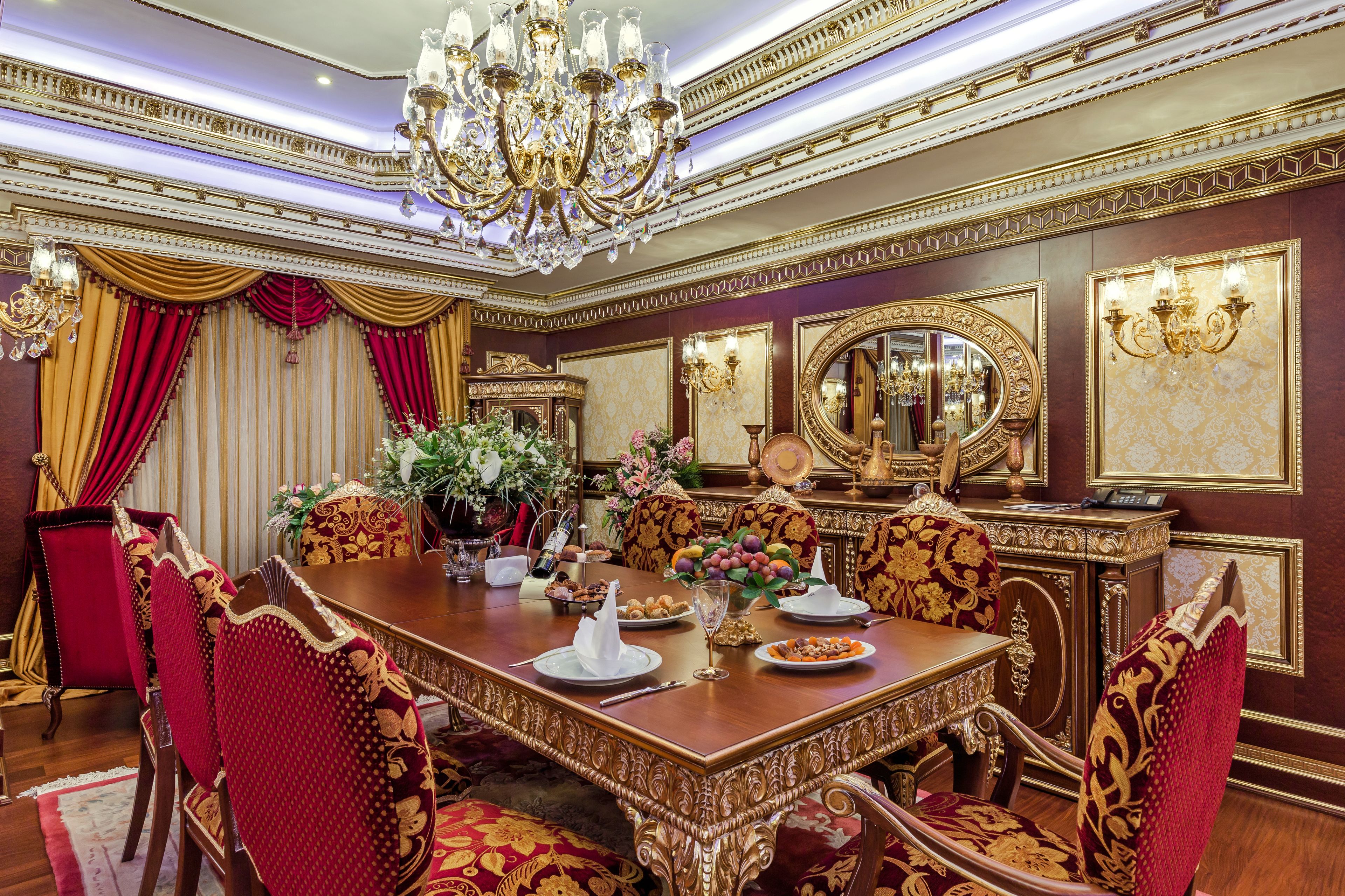 A formal dining room with a large wooden table, ornate chairs, and a chandelier.