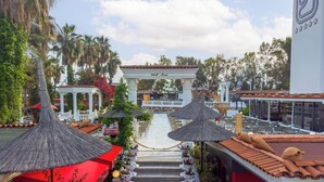 A hotel with a central courtyard, outdoor seating, and a traditional architectural style. - Club Hotel Sera - All Inclusive (Antalya)