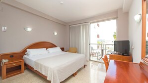 A hotel room with a bed, bedside table with a phone, a TV, a chair, and a balcony with a view. - Hotel Marfil (Sant Antoni de Portmany)