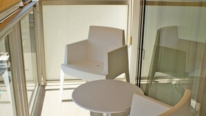A modern room with a glass partition, a white round table, and two white chairs. - Hotel Marfil (Sant Antoni de Portmany)