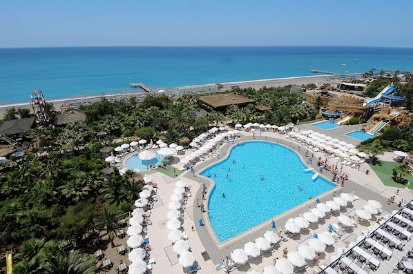 A resort with a large central pool, multiple smaller pools, and a beach area.