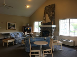 Cozy living room with a stone fireplace, sofa, and television.