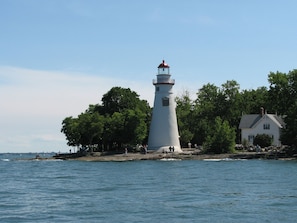 Perched on a rocky shoreline, this lighthouse offers breathtaking views of the surrounding greenery.
