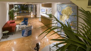 A lobby with a marble floor, a reception desk, a map on the wall, and seating areas. - Hotel Osiris Ibiza (Sant Antoni de Portmany)
