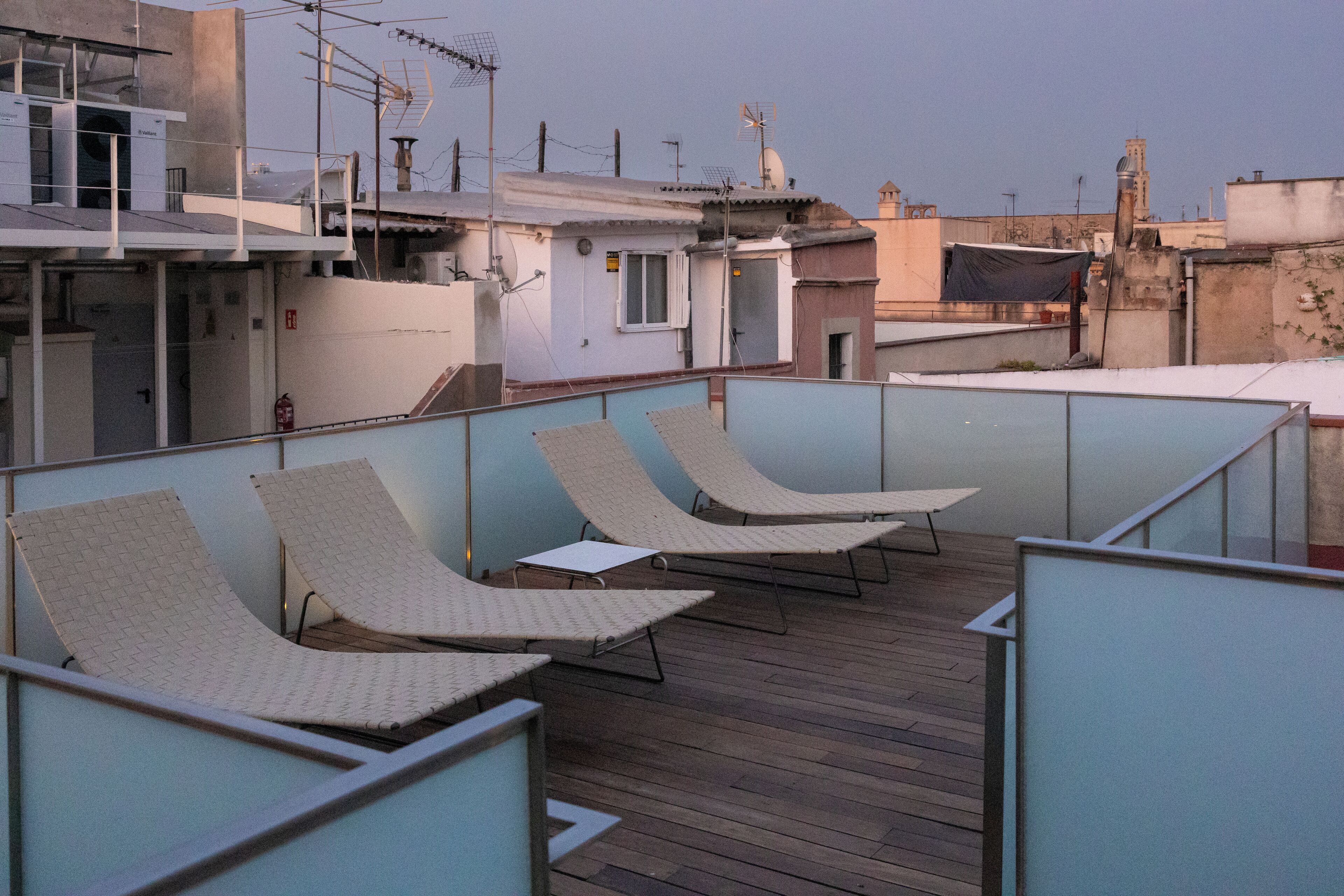 Una terraza en la azotea con sillones de descanso y una cubierta de madera.