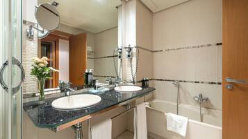 Un baño moderno con dos lavamanos, un espejo grande y una bañera.