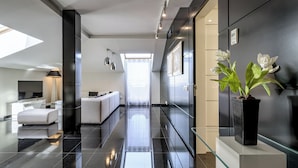 Un hall d’hôtel moderne avec une table basse en verre, un canapé et une plante en pot.