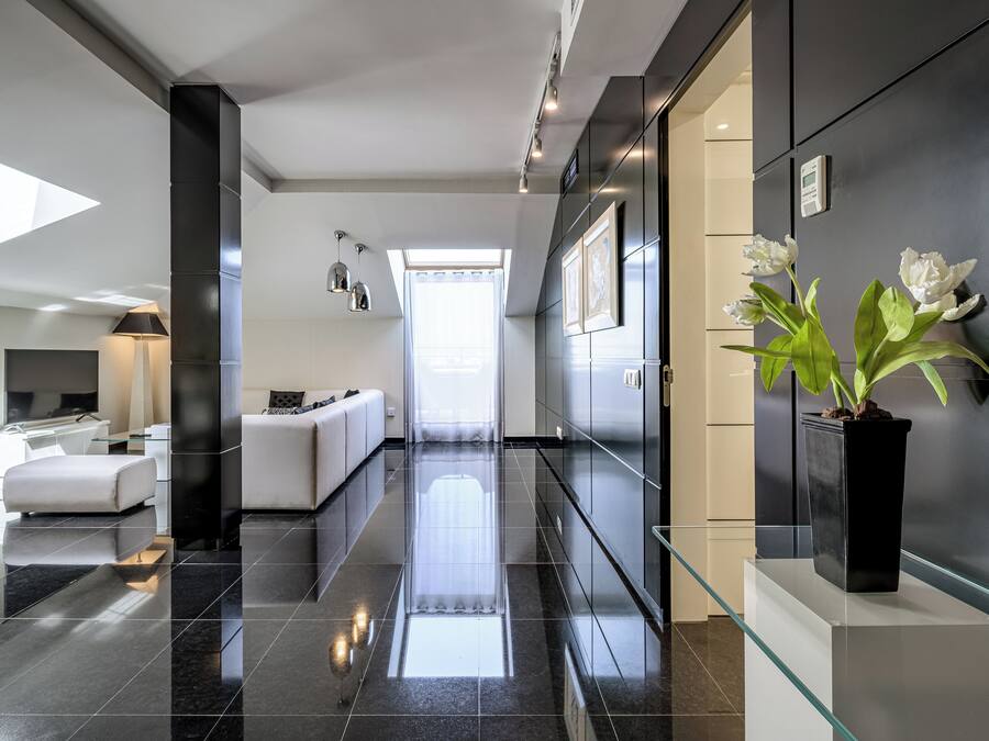 Un moderno vestíbulo de hotel con una mesa de centro de vidrio, un sofá y una planta en maceta.