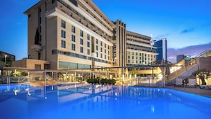 Un hôtel moderne doté d’une grande piscine, de plusieurs étages et d’un escalier imposant.