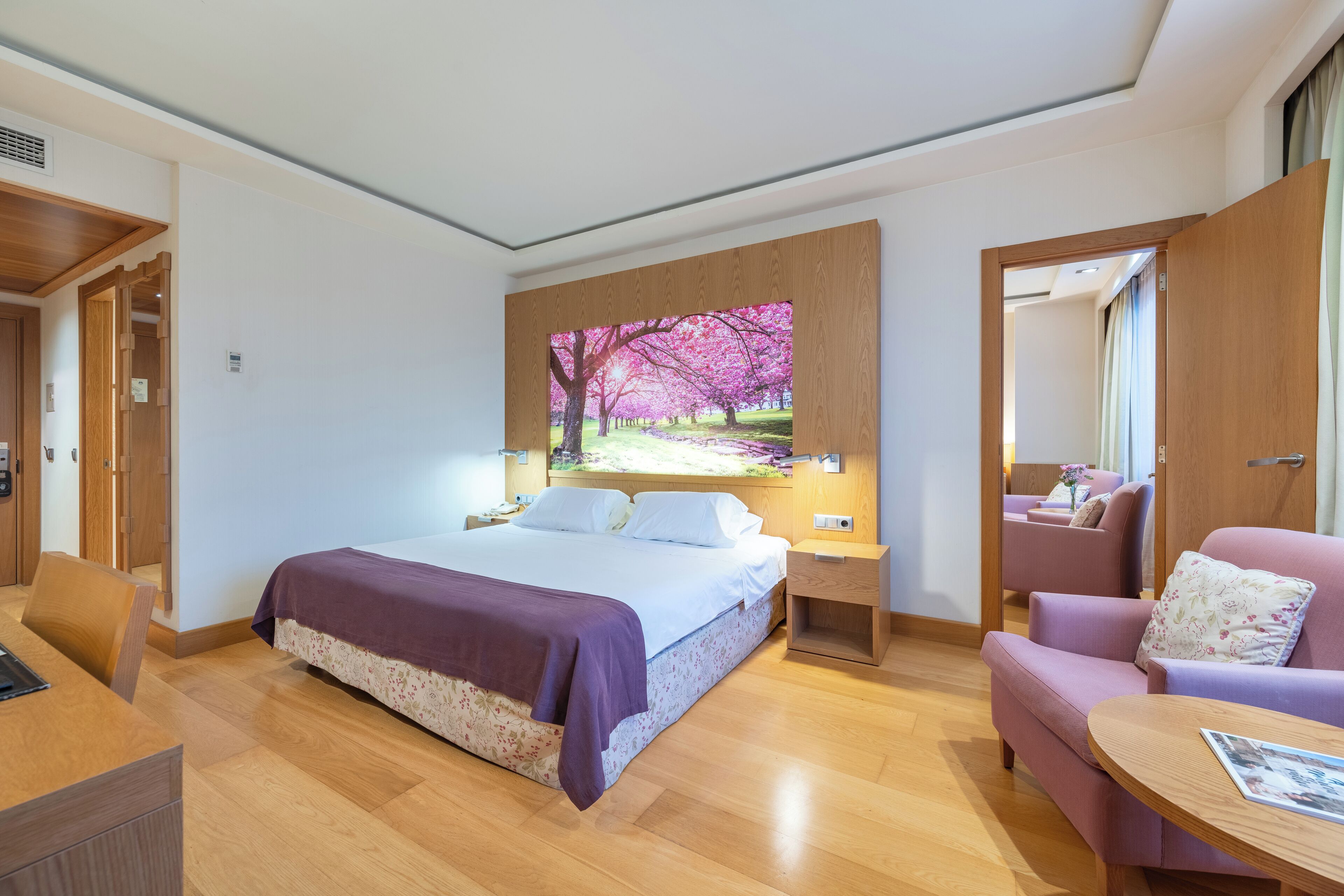 Een moderne hotelkamer met een groot bed, een bureau, een stoel en een bank.