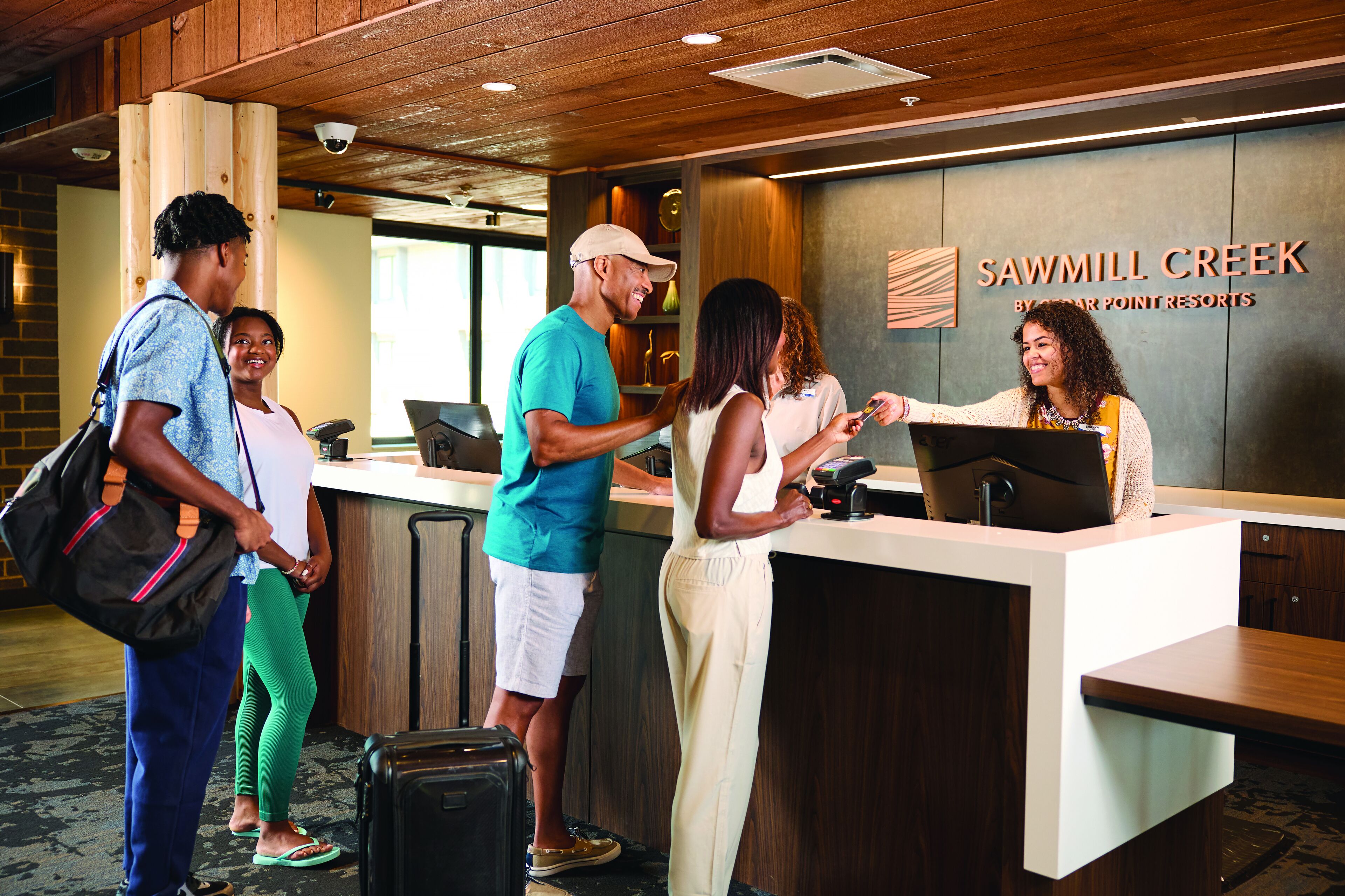 Una recepción en Sawmill Creek, parte de Grand Cypress Point Resorts, con un diseño moderno, techo de madera y una cámara de seguridad visible.