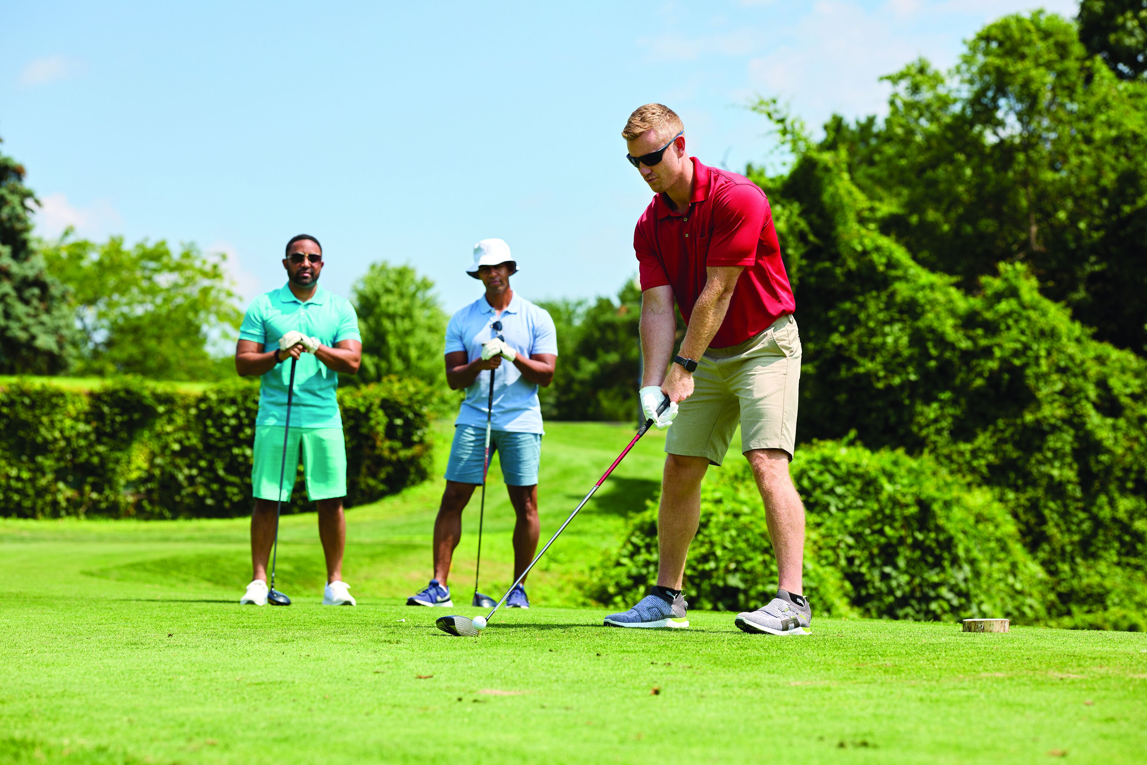 A golf course with players in various outfits.