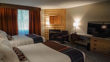Une chambre d’hôtel avec deux lits, un bureau avec une télévision, une chaise et une lampe.