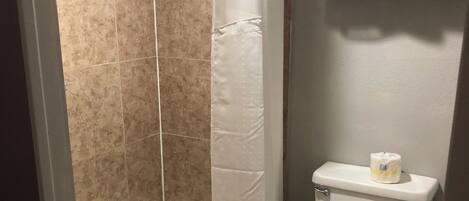 Un baño con bañera, inodoro y cortina de ducha.