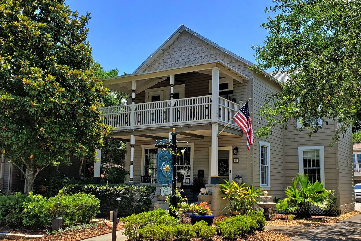 A two-story building with a balcony, an American flag, and a sign that reads "Journey's End."