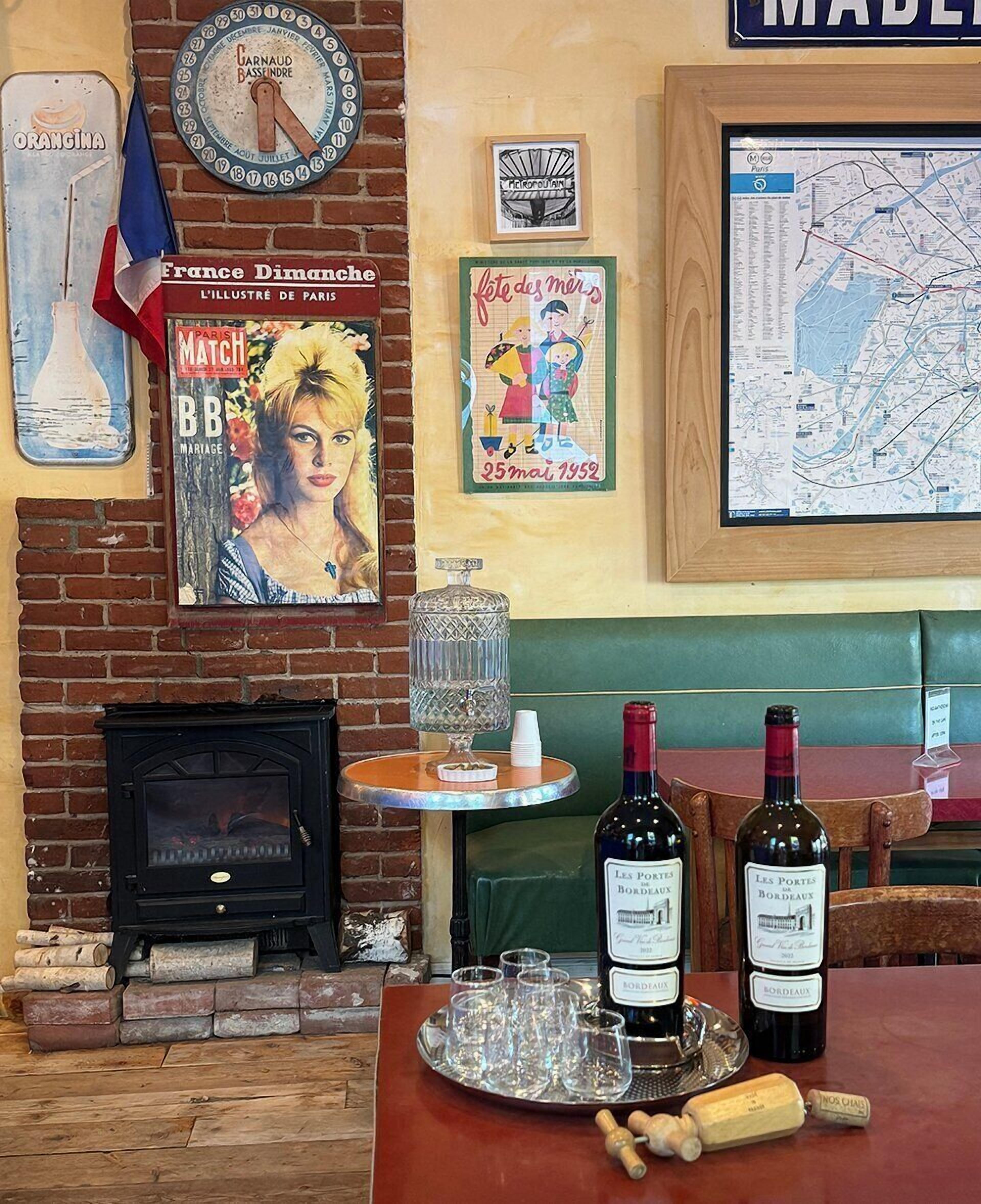 A cozy bar area with a brick fireplace, a map on the wall, and two bottles of wine on a tray.