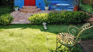 A blue house with a red door, a sign reading "ANNAS NEST," and a small patio area with a table and chairs. - Metro Hotel and Cafe (Petaluma)