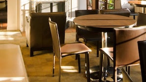 A dining area with a round table, chairs, a fireplace, and a staircase. - Casa Del Mar Inn (Santa Barbara)