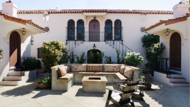 A courtyard with a curved seating area, a fire pit, and a bicycle. - Casa Del Mar Inn (Santa Barbara)